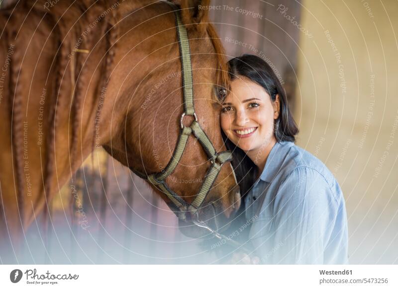 Portrait of smiling woman with a horse on a farm females women equus caballus horses portrait portraits smile Care caring care Adults grown-ups grownups adult