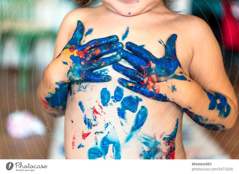 Toddler girl playing with finger paint making imprints on her chest human human being human beings humans person persons caucasian appearance