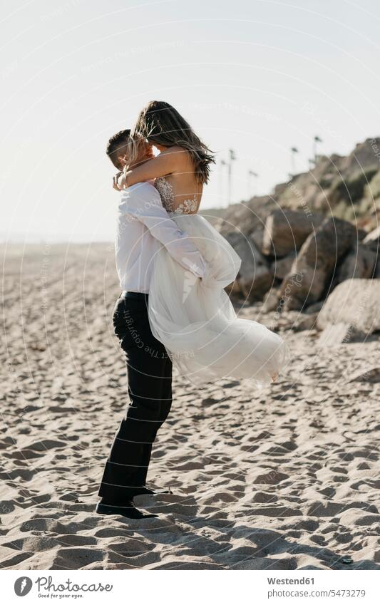 Happy bride and groom hugging on the beach human human being human beings humans person persons caucasian appearance caucasian ethnicity european 2 2 people