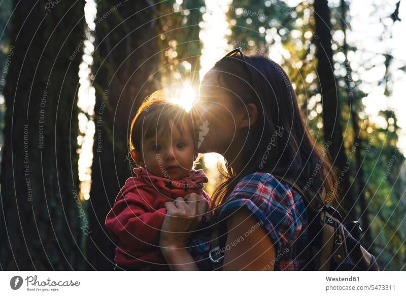 USA, California, Sequoia National Park, woman kissing her little daughter at sunset kisses daughters females women child children family families people persons