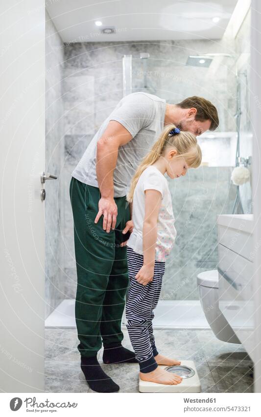 Father and daughter checking weight on bathroom scales Bath weight scales Instrument of Weight daughters Domestic Bathroom bath room weighing father pa fathers