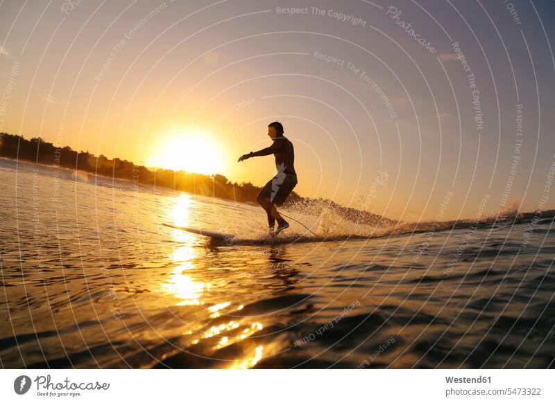 Surfer at sunset, Bali, Indonesia sports aquatics Water Sport watersports surf surf ride surf riding Surfboarding surf board surf boards surfboards stand