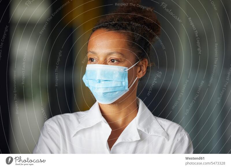 Portrait of businesswoman wearing light blue protective mask looking at distance business life business world business person businesspeople business woman