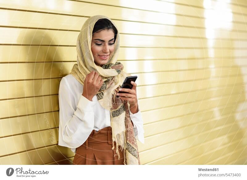 Spain, Granada, young Arab tourist woman wearing hijab, using smartphone females women Islam female Arabian female Arabs female Arabic female Arabians
