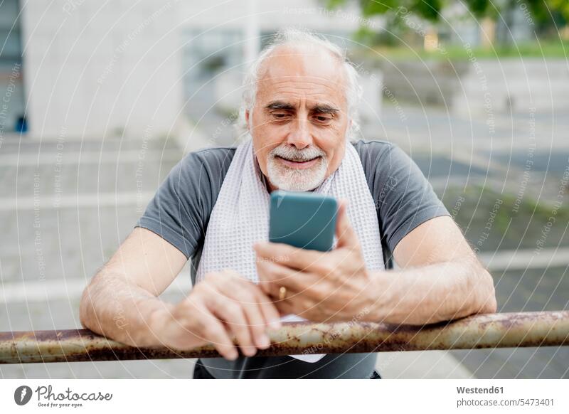 Close-up of senior man using smart phone while standing by railing color image colour image outdoors location shots outdoor shot outdoor shots day daylight shot