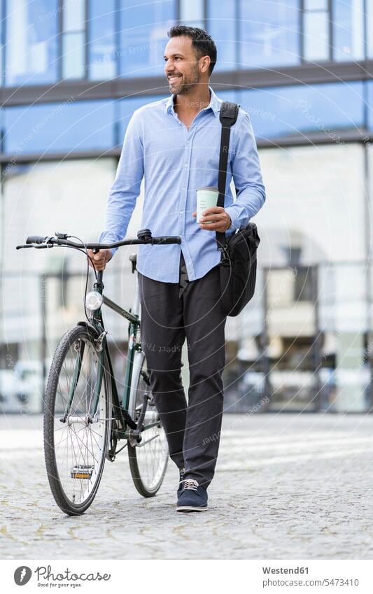 Businessman with bicycle on the go in the city Germany commuter commuters recyclable re-use re-usable ecological awareness green living healthy lifestyle