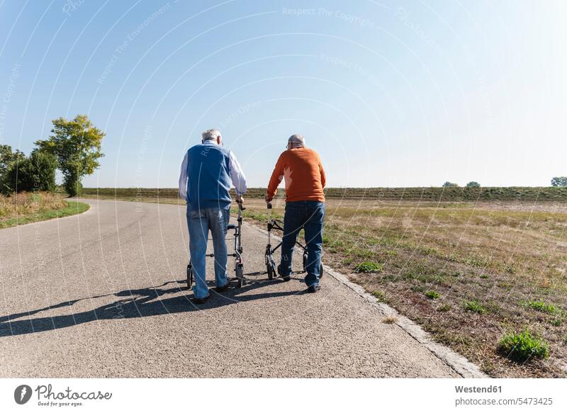 Two old friends walking on a country road, using wheeled walkers caucasian caucasian ethnicity caucasian appearance european Best Friend Best Friends Best Pal