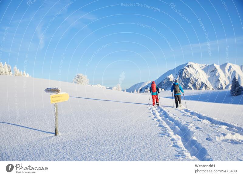 Austria, Tyrol, couple snowshoeing walking going winter hibernal twosomes partnership couples snowshoe hiker snowshoe hikers Orientation sign post