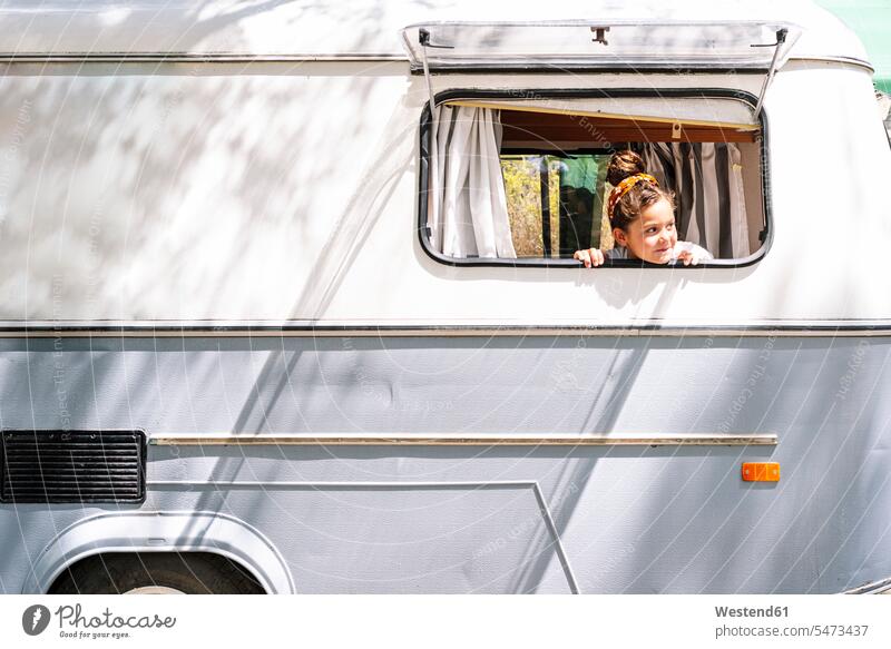 Girl looking through window while sitting in motor home color image colour image Spain leisure activity leisure activities free time leisure time outdoors