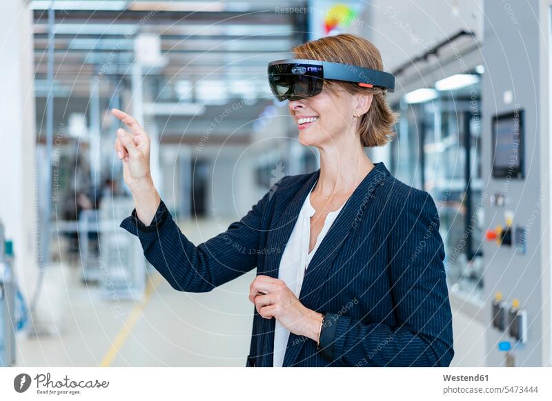 Smiling businesswoman wearing AR glasses in a modern factory Occupation Work job jobs profession professional occupation business life business world