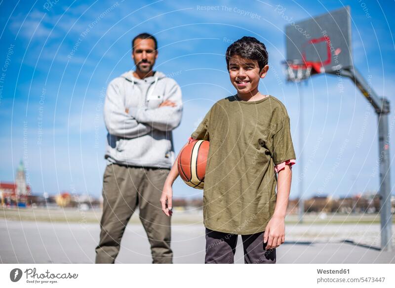 Portrait of boy with father on basketball court outdoors portrait portraits basketballs pa fathers daddy dads papa son sons manchild manchildren