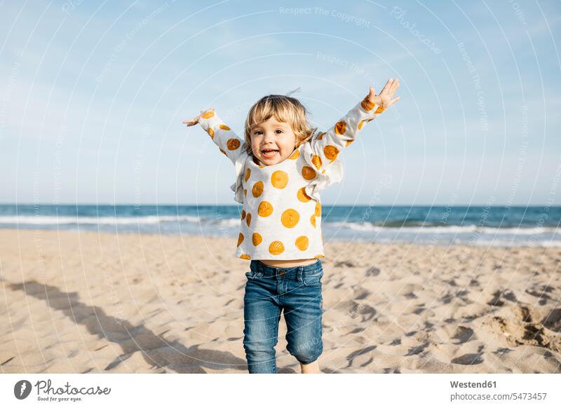 Portrait of happy little girl running on the beach Vitality Verve vigour vigorous Polka Dot Polka Dots Polka-Dot Polka-Dots portrait portraits exhilaration