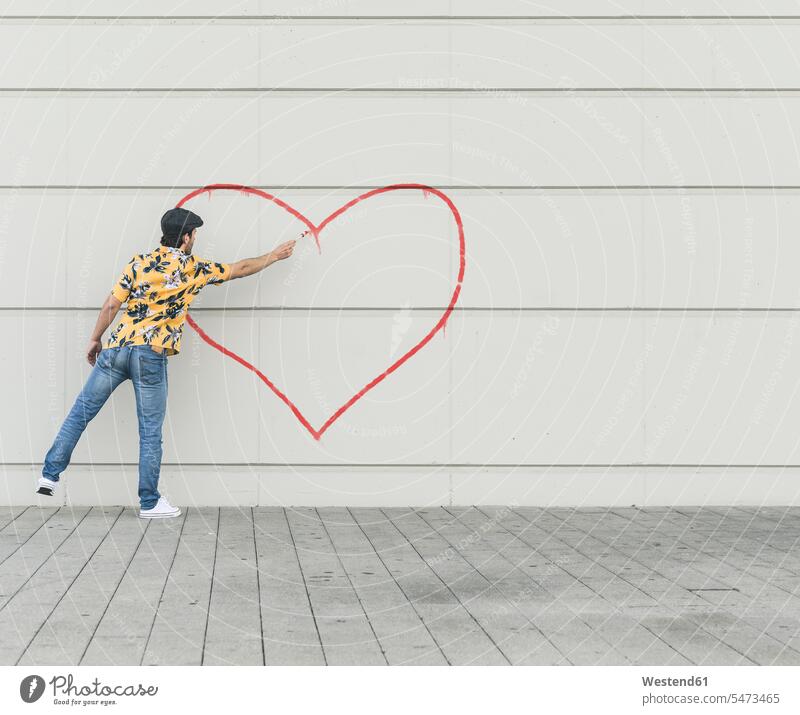 Digital composite of young man drawing aheart at a wall human human being human beings humans person persons caucasian appearance caucasian ethnicity european 1