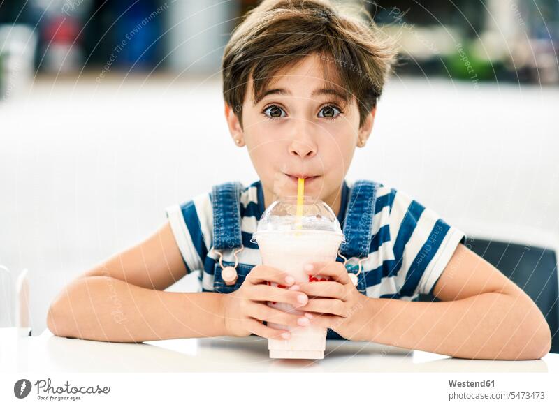 Portrait of little girl drinking strawberry milkshake at pavement cafe portrait portraits outdoor cafes stawberrry milk shake Milkshake Milkshakes females girls