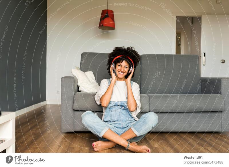 Happy woman sitting at home with headphones smiling smile Seated females women headset Adults grown-ups grownups adult people persons human being humans