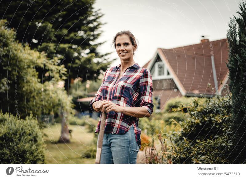 Proud home owner standing in her garden with a spade human human being human beings humans person persons caucasian appearance caucasian ethnicity european 1