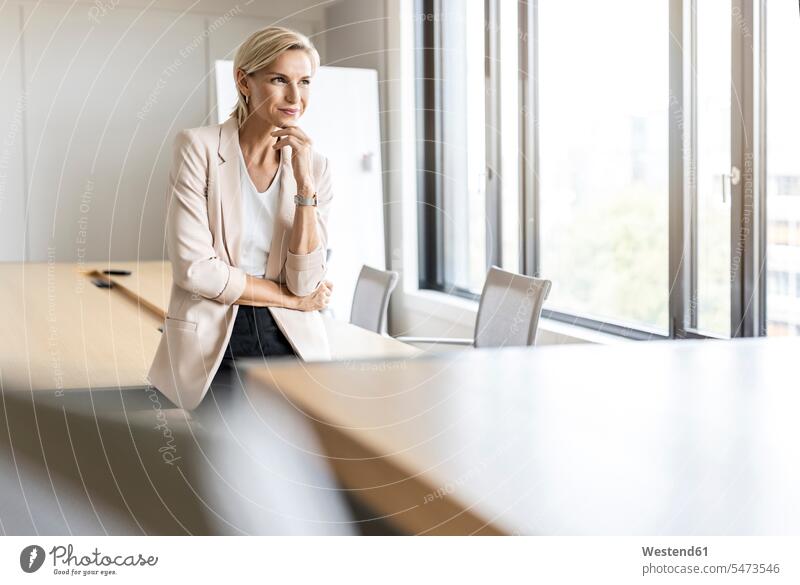 Blond businesswoman in conference room thinking Occupation Work job jobs profession professional occupation business life business world business person