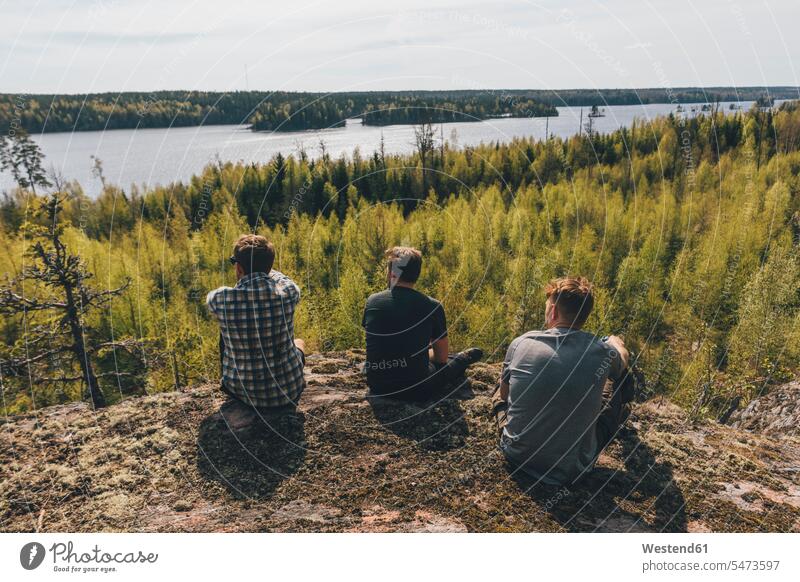 Friends sitting on hill, looking at lake, Nykoping, Sweden Seated peaceful peacefulness on the go on the road on the way Adventures adventurous Bodies of Water