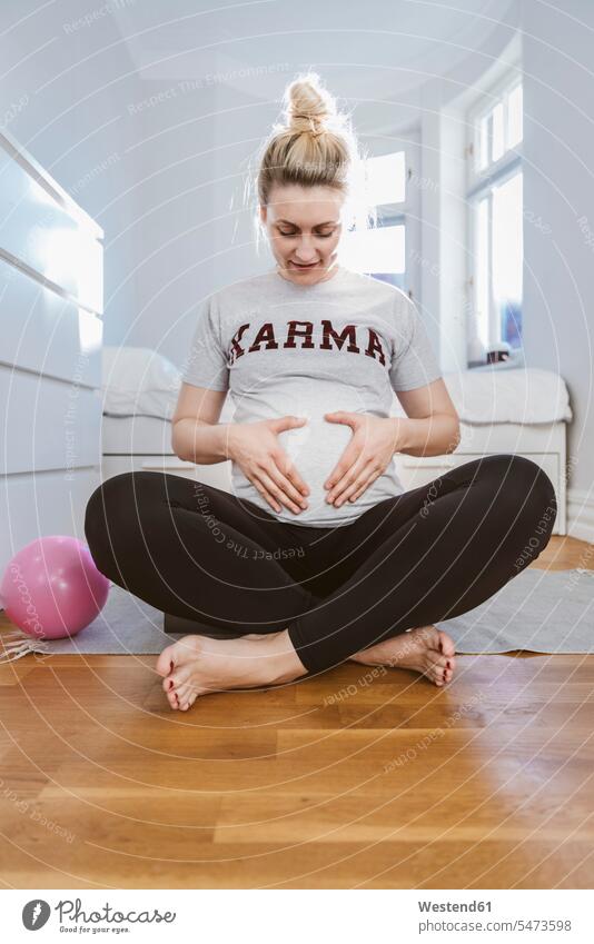 Pregnant woman practising with a ball at home windows balls exercise train training touch smile Seated sit exercising practice practise relax relaxing