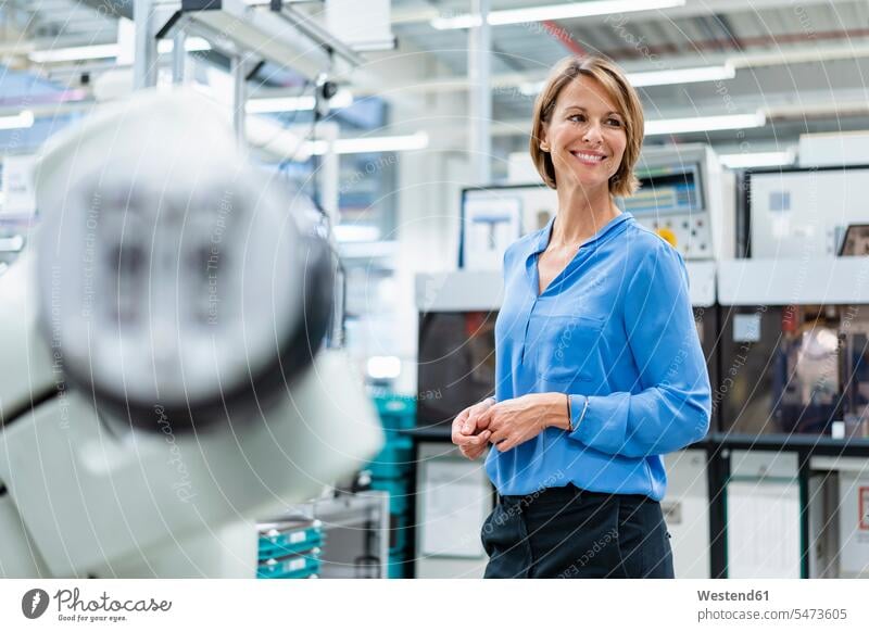 Portrait of businesswoman at assembly robot in a factory Occupation Work job jobs profession professional occupation business life business world