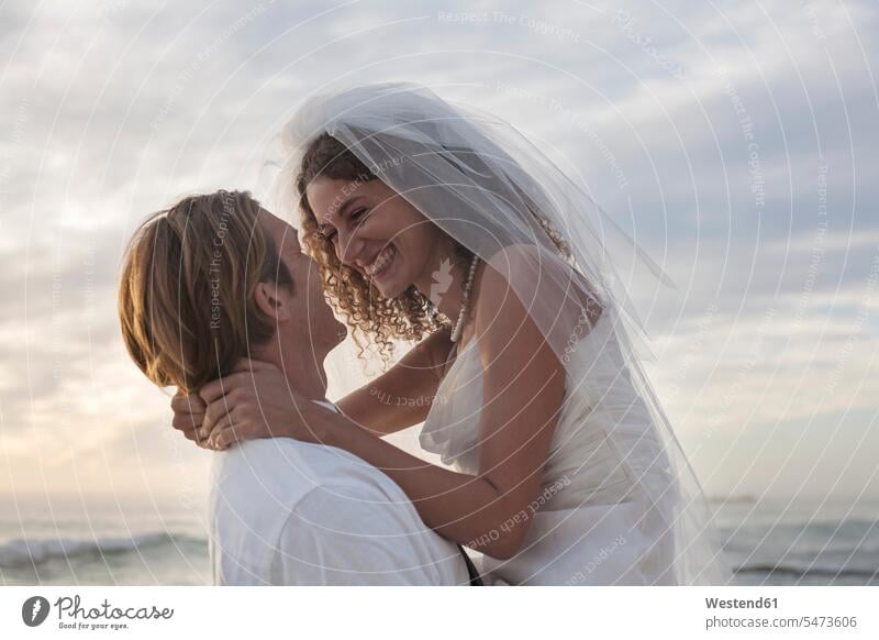 Romantic newlyweds at beach against sky during sunset color image colour image South Africa outdoors location shots outdoor shot outdoor shots sunsets sundown