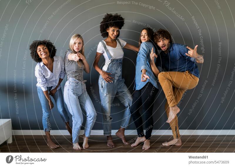 Group portrait of friends standing at a wall posing walls pose Posed portraits friendship Spain leisure free time leisure time African descent female African