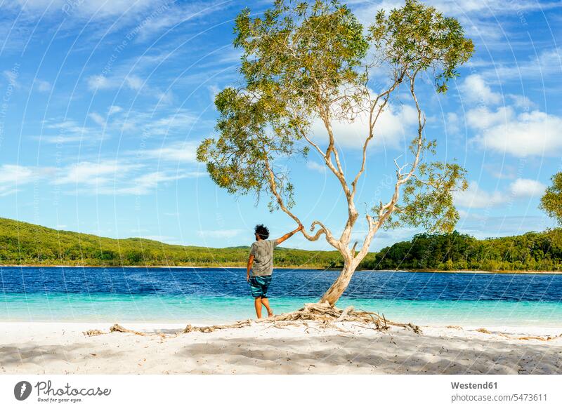 Man looking at Lake Mckenzie against sky, Fraser Island, Queensland, Australia color image colour image outdoors location shots outdoor shot outdoor shots day