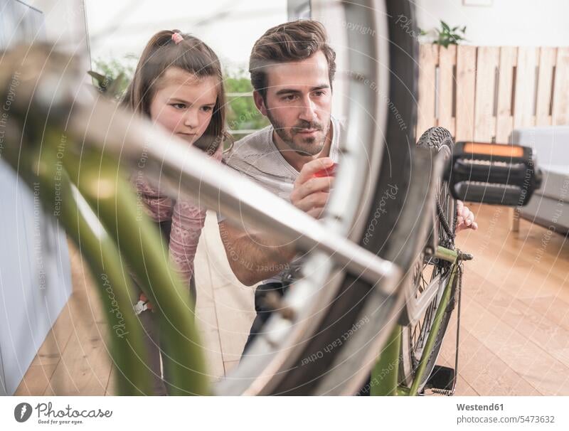 Young man and little girl repairing bicycle together Germany Sustainable transport Quality Time Single Father Showing show one parent sustainability sustainable