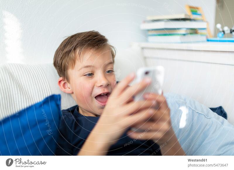Boy playing with his smartphone during the corona crisis human human being human beings humans person persons caucasian appearance caucasian ethnicity european