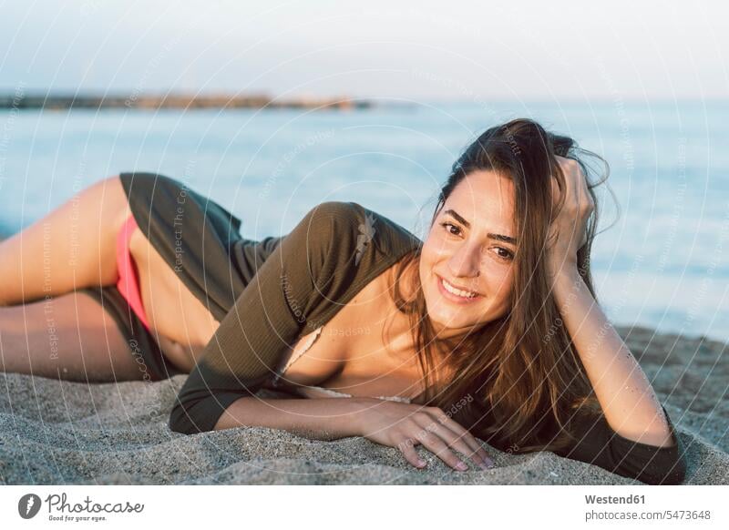 Beautiful woman relaxing on the beach at sunset, portrait beaches sunsets sundown smiling smile relaxation relaxed sea ocean beautiful Woman beautiful Women