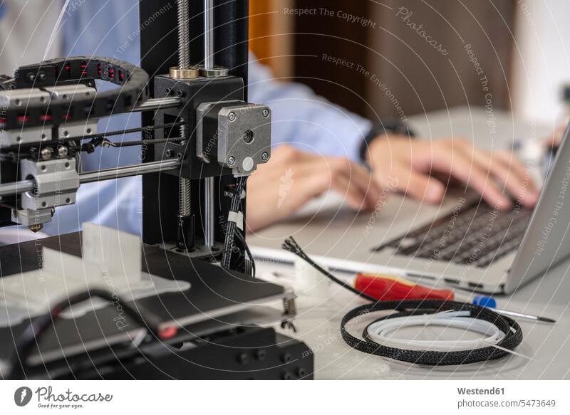 Student setting up 3D printer,using laptop, close up human human being human beings humans person persons caucasian appearance caucasian ethnicity european 1