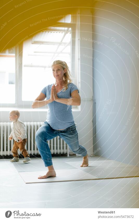 Pregnant woman with toddler son practicing yoga pregnant Pregnant Woman practice practise exercise exercising practising sons manchild manchildren females women