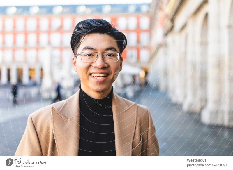Spain, Madrid, portrait of happy young man at Plaza Mayor square plaza places Public Square city town cities towns men males happiness portraits outdoors