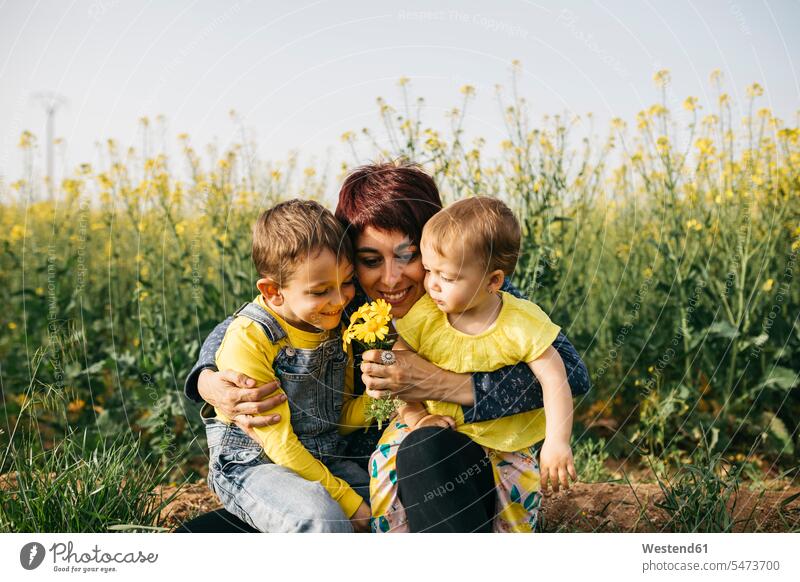 Happy mother with little son and daughter in nature natural world sons manchild manchildren daughters mommy mothers mummy mama family families people persons