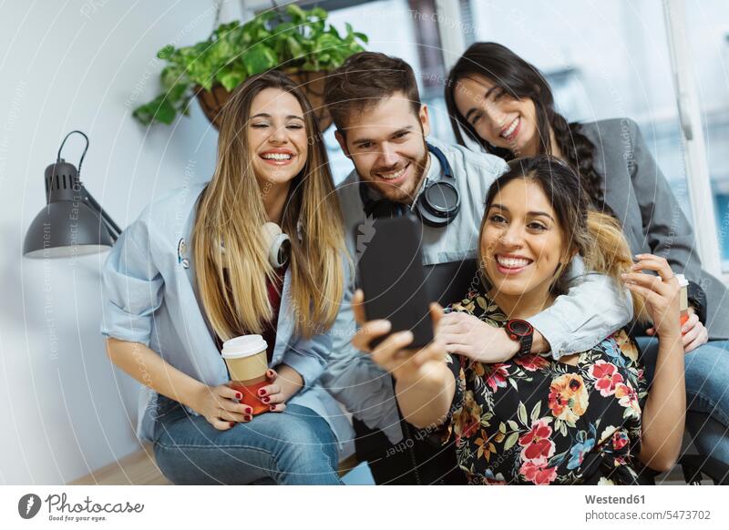 Happy casual coworkers in the office taking a selfie offices office room office rooms Selfie Selfies Coworker happiness happy workplace work place place of work