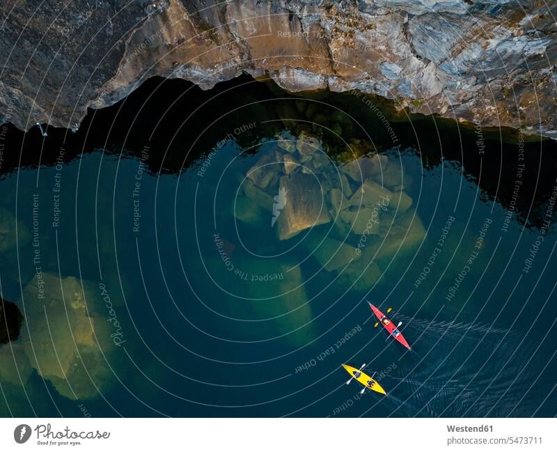 Russia, Republic of Karelia, Sortavala, Aerial view of kayakers sailing over sunken boulders in Lake Light outdoors location shots outdoor shot outdoor shots