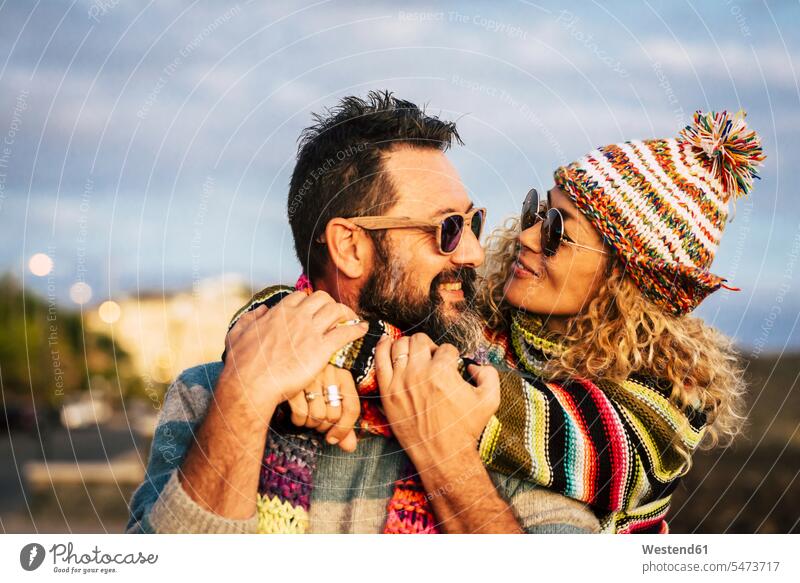 Mature couple hugging each other, Tenerife, Spain scarfs scarves Eye Glasses Eyeglasses specs spectacles Pair Of Sunglasses sun glasses cuddle snuggle snuggling