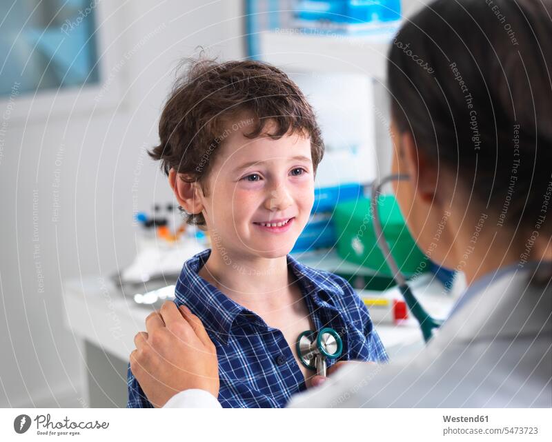 Female doctor examiming a boy in a clinic health healthcare Healthcare And Medicines medical medicine doctors physician physicians Female Doctors examinations