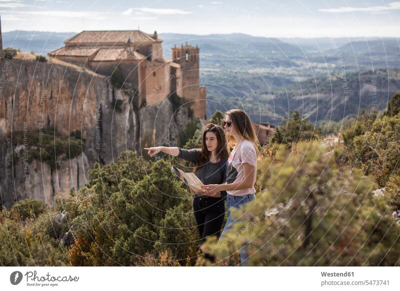 Spain, Alquezar, two young women with map on a hiking trip female friends hike woman females maps mate friendship Adults grown-ups grownups adult people persons