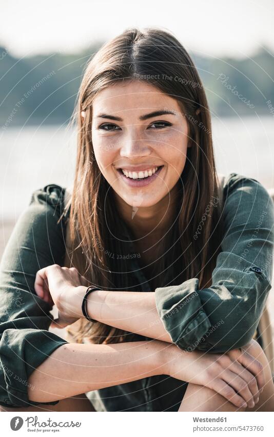 Portrait of smiling young woman sitting outdoors smile Seated portrait portraits females women Adults grown-ups grownups adult people persons human being humans