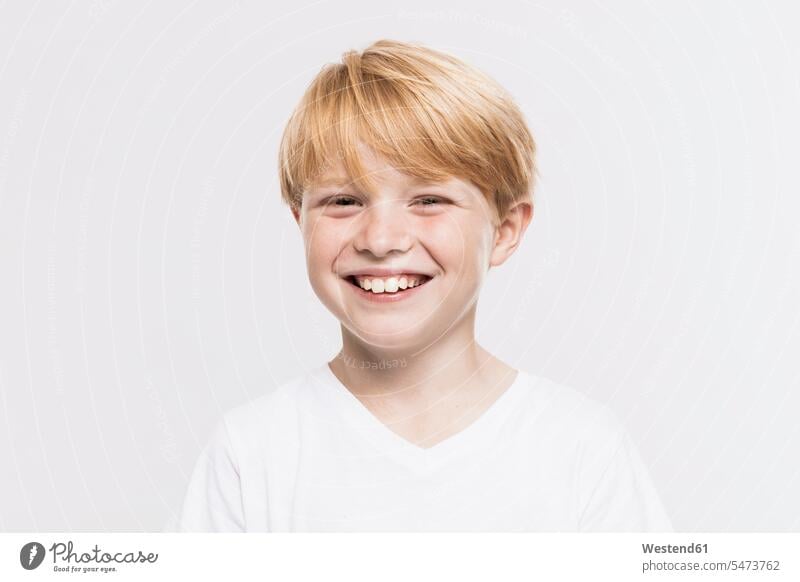 Cheerful cute boy with blond hair against white background 8-9 years 8 to 9 years children kid kids people human being human beings humans persons close-up