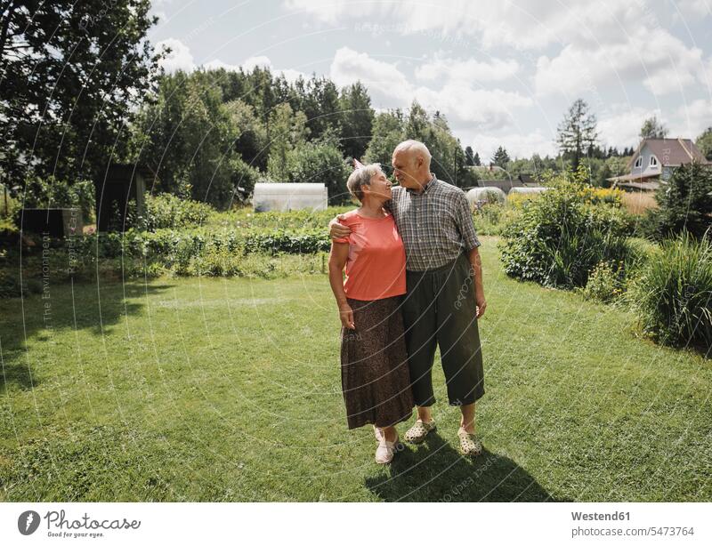 Happy senior couple standing in the garden elder couples senior couples happiness happy portrait portraits gardens domestic garden adult couple adult couples
