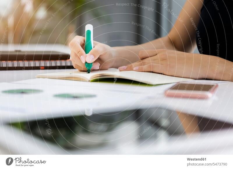 Close-up of businesswoman writing on book at desk in office color image colour image Germany indoors indoor shot indoor shots interior interior view Interiors