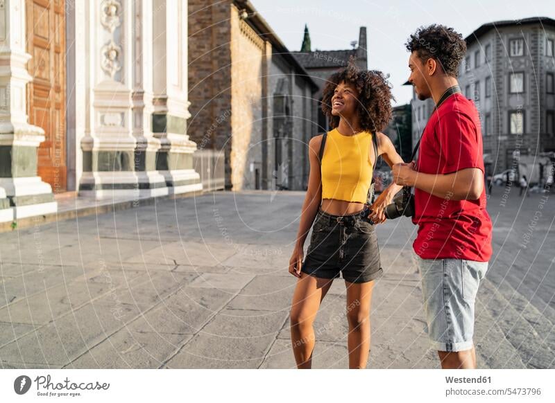 Happy young tourist couple exploring the city, Florence, Italy touristic tourists human human being human beings humans person persons curl curled curls