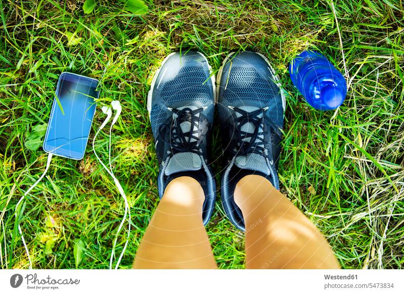 Running shoes, smartphone with earphones, water bottle, overhead view meadow meadows break headphones headset Water Smartphone iPhone Smartphones drinking woman
