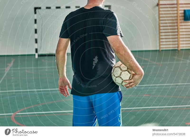 Rear view of indoor soccer player holding the ball football football player footballers football players soccer players balls man men males sport sports Adults