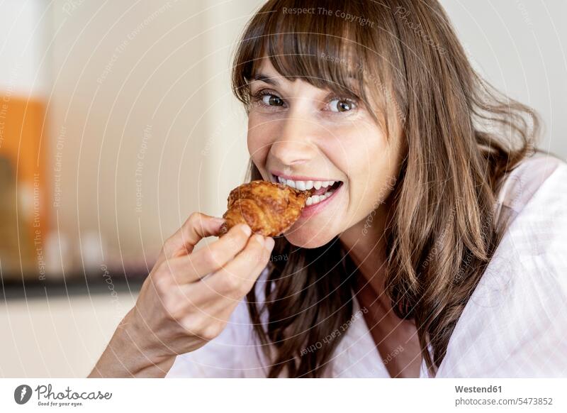 Portrait of happy woman eating a croissant human human being human beings humans person persons caucasian appearance caucasian ethnicity european 1
