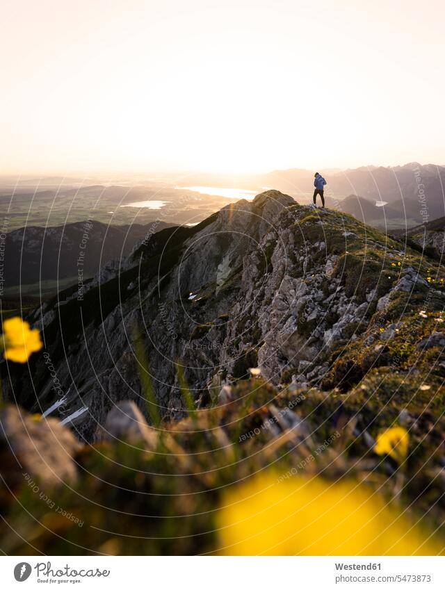 Female hiker on viewpoint during sunrise, Brentenjoch, Bavaria, Germany hiking - trekking wander wandering in the morning Yellow - Color free Liberty Adventures