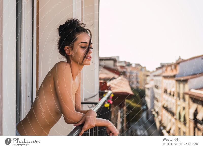 Beautiful barechested young woman on balcony above the city beautiful leaning rested on semi-dressed naked Nudeness Nudity undressed nude town cities towns