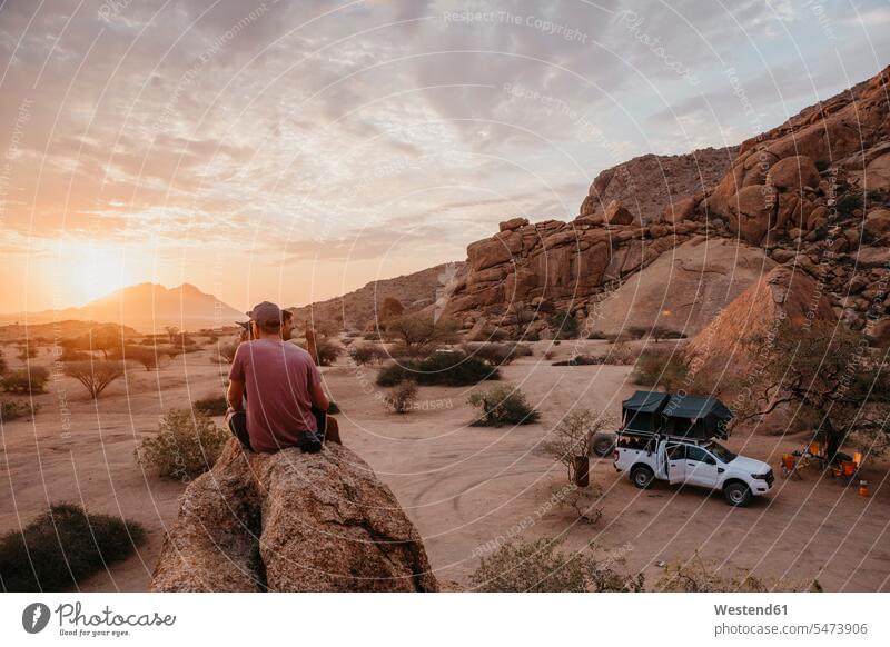 Namibia, Spitzkoppe, friends sitting on a rock watching the sunset sunsets sundown rocks Seated atmosphere atmospheric mood moody Atmospheric Mood Vibe Idyllic